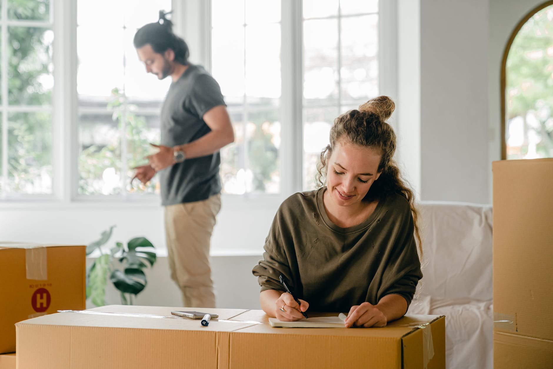 cheerful young spouses preparing for moving in new apartment