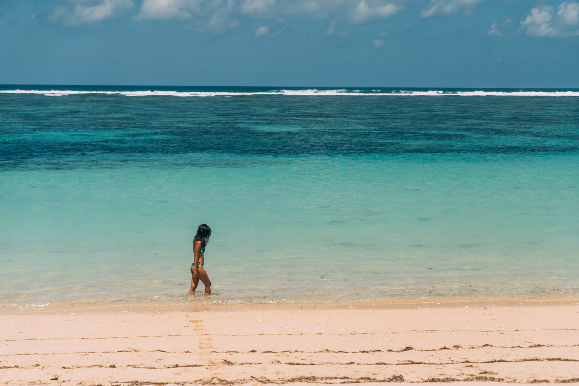 a woman in bikini walking on beach