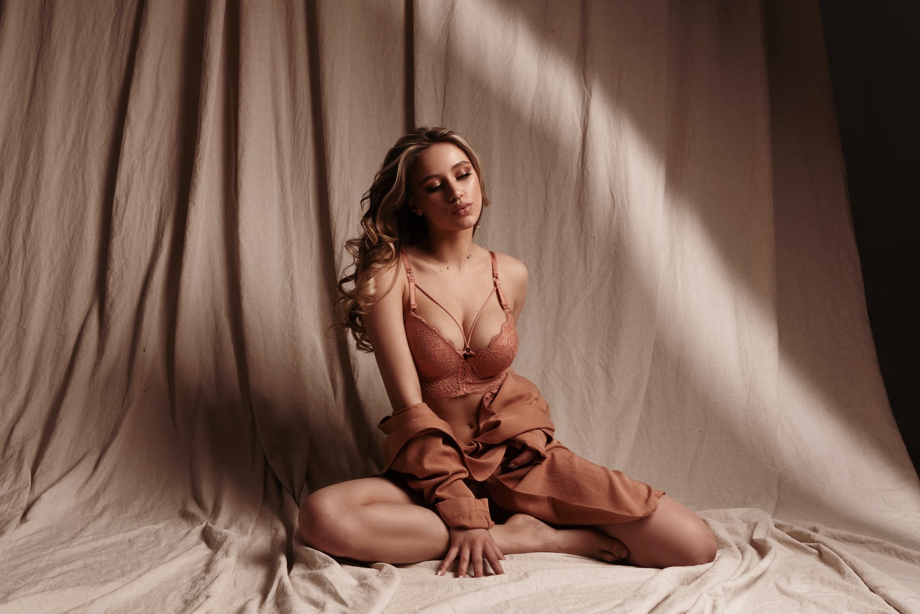 woman in bra sitting on the studio floor