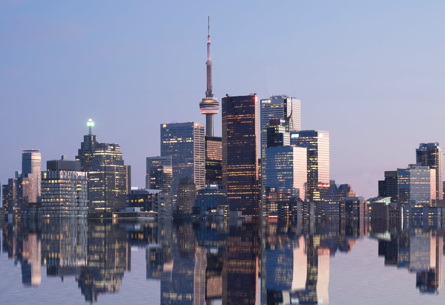 city skyline near body of water during night time