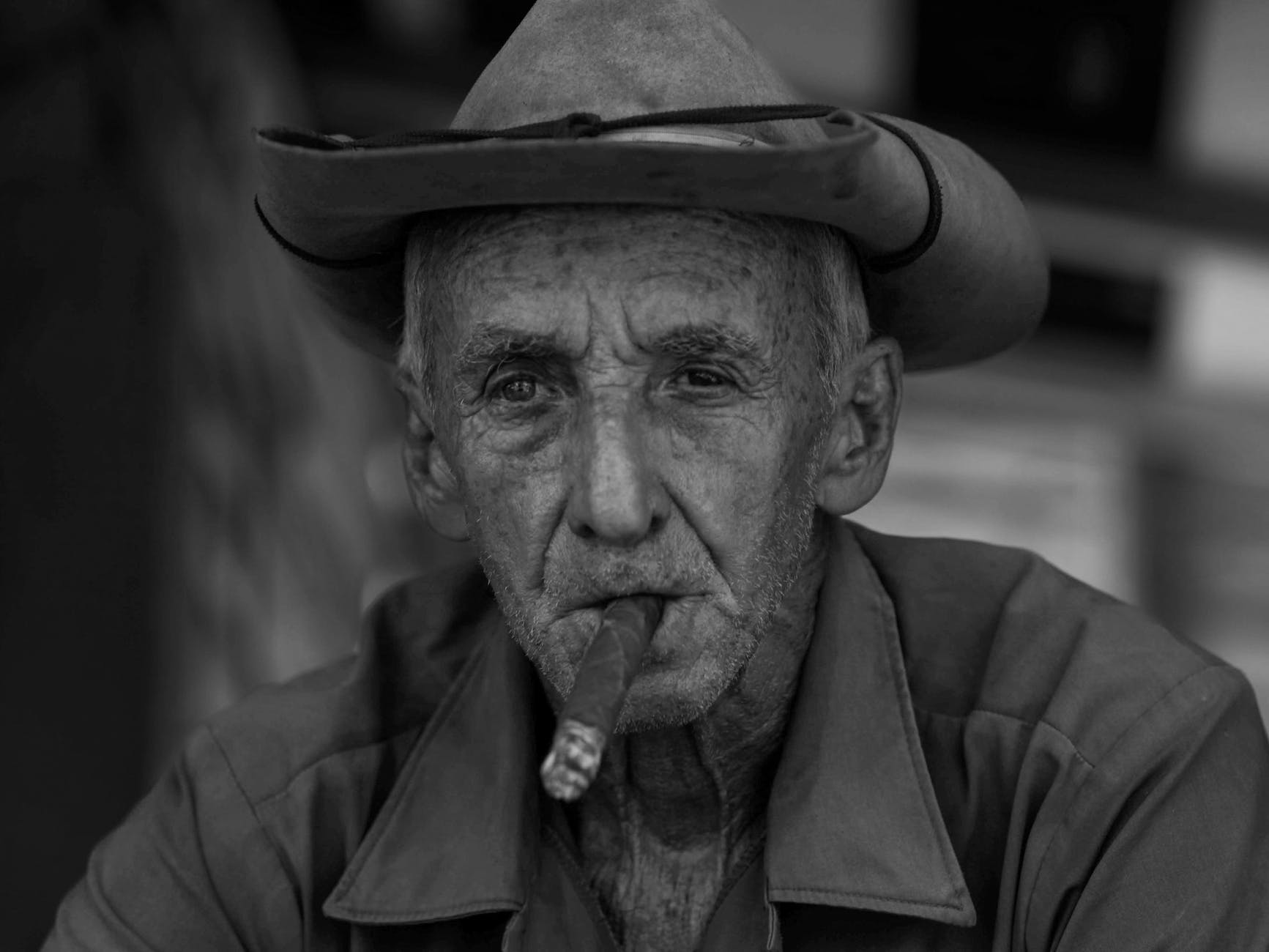 grayscale photo of an elderly man wearing cowboy hat