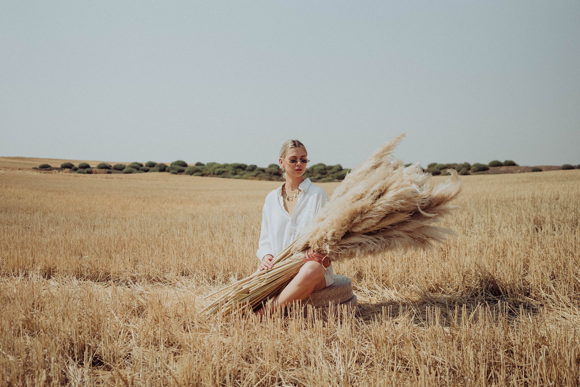 calm woman in see through shirt with dried grass